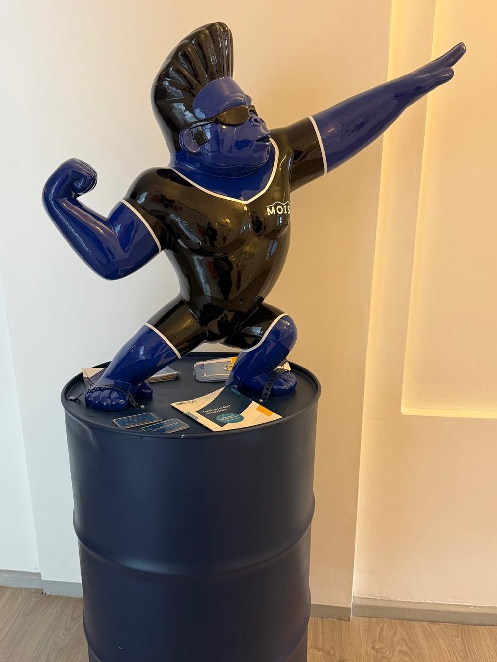 Gorilla-Skulptur in Blau und Schwarz mit MOIS-Logo auf einem Fass im Eingangsbereich